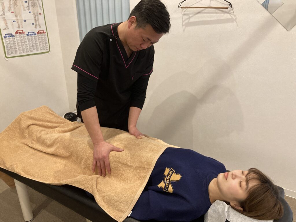 松戸市串崎新田のあき接骨院院長の筒井豪（つついたくま）が女性ホルモンの乱れで悩んでいる方に、全身を調整して矯正・整体をしている写真