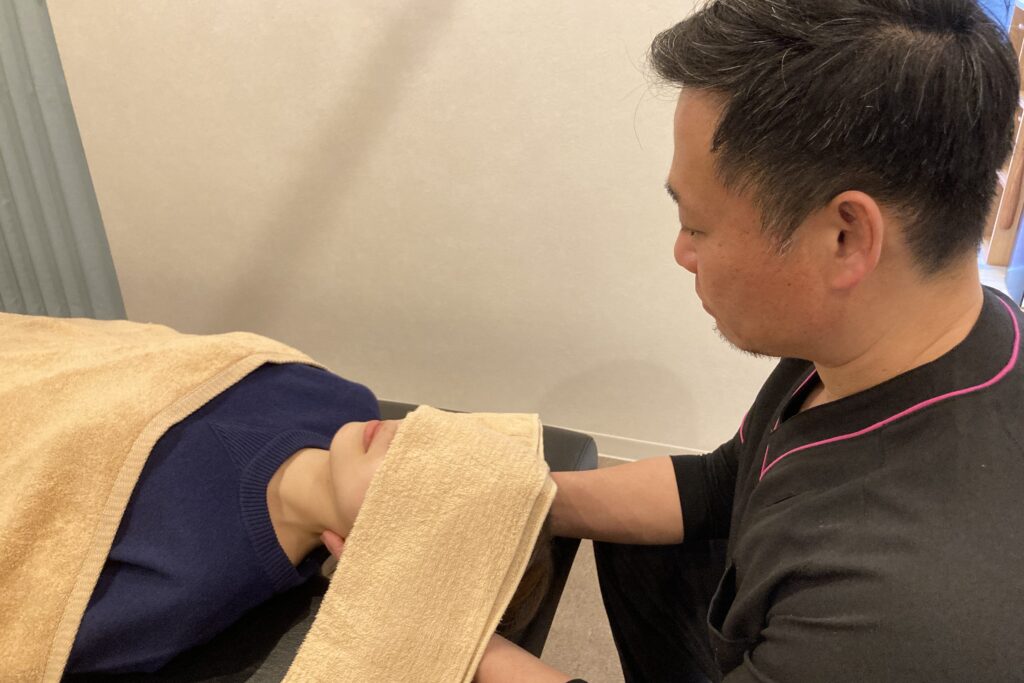 松戸市串崎新田のあき接骨院院長の筒井豪（つついたくま）が後鼻漏で悩んでいる方に、全身を調整して矯正・整体をしている写真